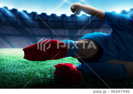 Football player man in a blue jersey with tackling the ball 96897496