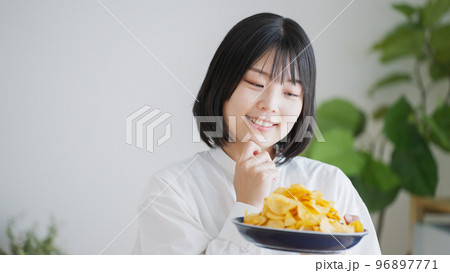 ポテトチップスを食べる女性（不健康・ダイエット）.. 96897771