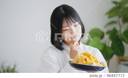 ポテトチップスを食べる女性（不健康・ダイエット）.. 96897772