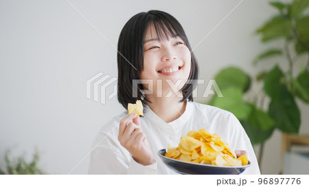 ポテトチップスを食べる女性（不健康・ダイエット）.. 96897776