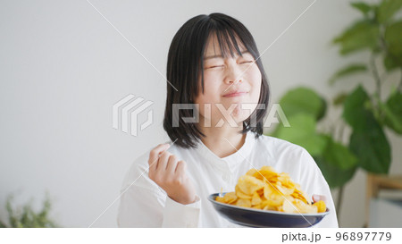 ポテトチップスを食べる女性（不健康・ダイエット）.. 96897779