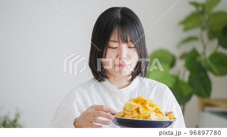 ポテトチップスを食べる女性（不健康・ダイエット）.. 96897780