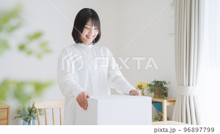 ダンボールを開ける女性（引越し・梱包） 96897799