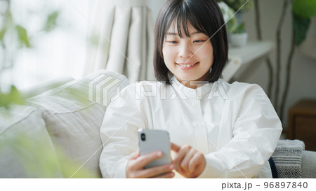 スマートフォンを操作するミドル女性.. スマートフォンを操作するミドル女性.. 96897840