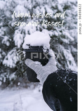 Warm wishes and snowman kisses Inspiration joke quote phrase Female hand in winter warm gloves holding black eco paper cup. Creative trendy zero waste recycle cup. Hot warming drink winter day 96898822