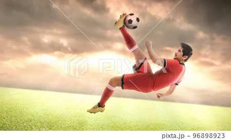Asian football player man in a red jersey kicking the ball 96898923