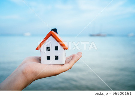 mortgage calculator or real estate business concept. white house in a palm against blue sea water. Seaside rent or vacation house. Loan or insurance rate payments guidance support. Liability and risk 96900161