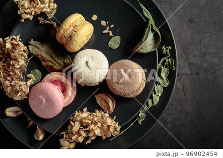 Macaroons with dried flowers on a black plate. Macaroons with dried flowers on a black plate. 96902454