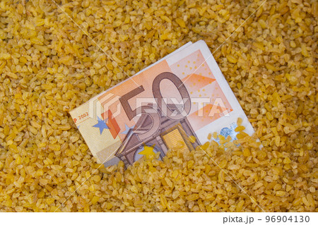 Euro bill paper money currency banknote in buckwheat porridge. The crisis in the market of grain crops, the rise in prices or production volumes of buckwheat Food and groceries shopping price increase 96904130