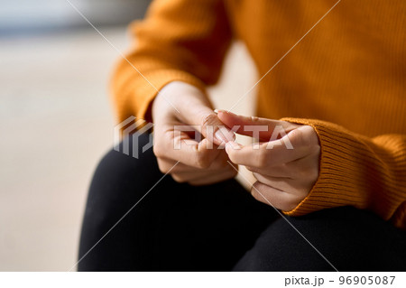 ストレスで爪をいじる女性の手元 96905087