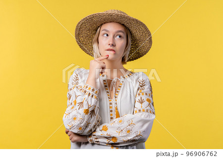 Ukrainian pensive woman on yellow background. Smart thinking student girl finding answer gesture or 96906762