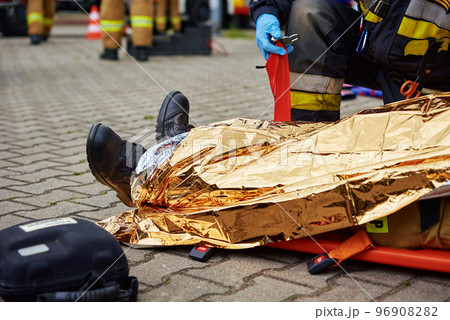 Rescuers provide first aid to the victim during car road accident Rescuers provide first aid to the victim during car road accident 96908282