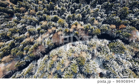 Snowy landscape with winding mountain road, view from above. Snowy landscape with winding mountain road, view from above. 96908947
