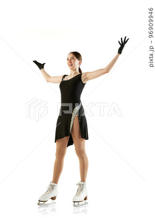 Wow, success, win. Happy young girl, female figure skater in black stage costume standing with raising hands isolated over white background. Sport, beauty, winter sports Wow, success, win. Happy young girl, female figure skater in black stage costume standing with raising hands isolated over white background. Sport, beauty, winter sports 96909946
