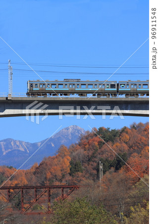 紅葉色づく旧立場川橋梁と八ヶ岳を背景に駆け抜ける211系電車_2022/11/18撮影 96911548