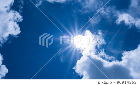 Aerial view of beautiful sky with clouds and sun on a summer day. Time lapse of clouds above the blue sky with the sun shining. Sky nature background. Aerial view of beautiful sky with clouds and sun on a summer day. Time lapse of clouds above the blue sky with the sun shining. Sky nature background. 96914565