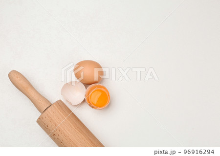 Raw eggs and rolling pin on white table, top view with space for text. Baking pie Raw eggs and rolling pin on white table, top view with space for text. Baking pie 96916294