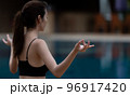 Woman meditating at swimming pool. 96917420