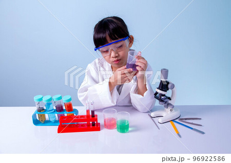 Little asian cute girl learning a scientist in biology lab with equipment and looking at liquid chemicals in tube. Learning and education of kid. 96922586