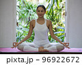 Asian happy woman doing yoga meditating pose at home. 96922672