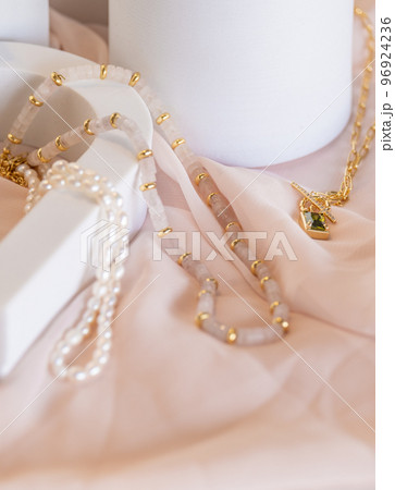 Girl jewelry accessories pearl, peridot and pink quartz necklaces on display 96924236