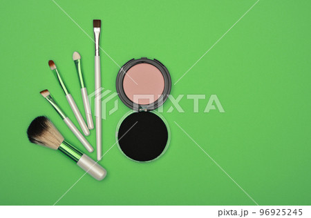 Make up blush, sponge and brushes over green Make up blush, sponge and brushes over green 96925245