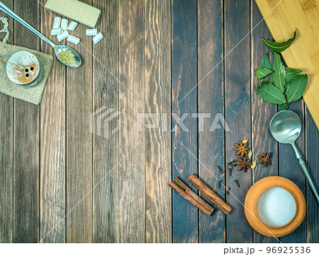 Old wood table with cinnamon, marshmallow, waffles, star anise, peppercorns, bay leaf, cloves. Background of wooden texture. Close-up pattern. 96925536