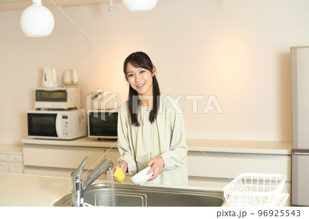 キッチンで洗い物をする若いアジア人女性 96925543