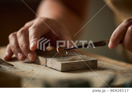Close up of artisan jeweler holding handmade ring Close up of artisan jeweler holding handmade ring 96926517