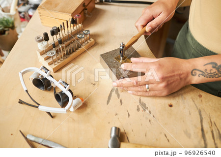 Artist creating handmade jewelry 96926540