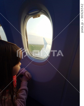 Girl look in airplane window Girl look in airplane window 96926542