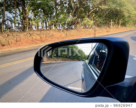 Looking through the rearview mirror on a street without much traffic 96926947