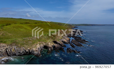 Vegetation-covered rocks on the shore of the Celtic Sea near the town of Clonakilty, County Cork, Ireland. Beautiful seascape. Nature on the Wild Atlantic Way. A natural attraction. Aerial photo. Vegetation-covered rocks on the shore of the Celtic Sea near the town of Clonakilty, County Cork, Ireland. Beautiful seascape. Nature on the Wild Atlantic Way. A natural attraction. Aerial photo. 96927057