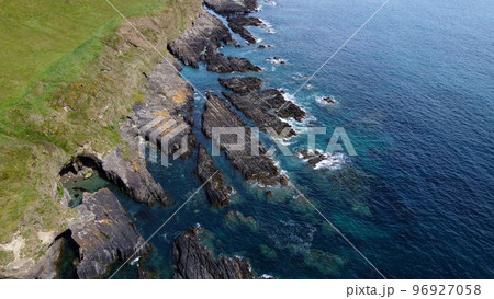 Rocky shores of the Celtic Sea along the route of the Wild Atlantic Way, top view. Seascape of the southern coast of Ireland. Beautiful rocky slopes. Aerial photo. Rocky shores of the Celtic Sea along the route of the Wild Atlantic Way, top view. Seascape of the southern coast of Ireland. Beautiful rocky slopes. Aerial photo. 96927058