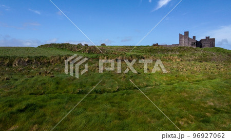 An old unfinished building on a green hill. Beautiful sky with clouds. 96927062