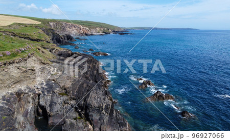 Farm fields on the rocky shore of the Celtic Sea, south of Ireland, County Cork. Beautiful coastal area. Turquoise waters of the Atlantic. Picturesque stone hills. Aerial photo. 96927066