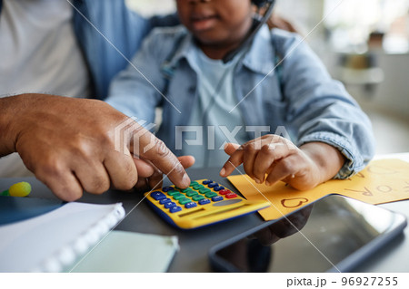 Close up of father and child playing with toy calculator 96927255