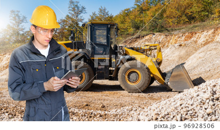 Engineer in a helmet with a digital tablet Engineer in a helmet with a digital tablet 96928506