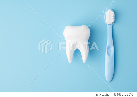Toy tooth and toothbrush on blue background, flat lay 96931570