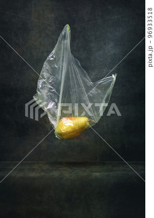 Ripe pear in a cellophane bag on a string on a dark background Ripe pear in a cellophane bag on a string on a dark background 96933518