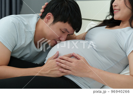 Husband kissing to pregnant wife's belly 96940266