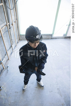 建築現場で手袋をする作業員男性 96940397