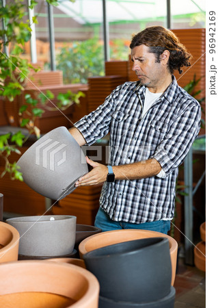 Handsome man choosing pots for flowers and trees in gardening market 96942169