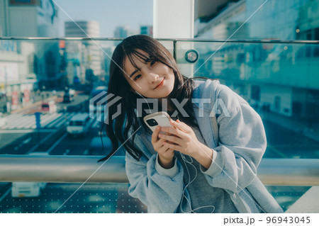女子高生と街中でのスマホを持った写真 96943045