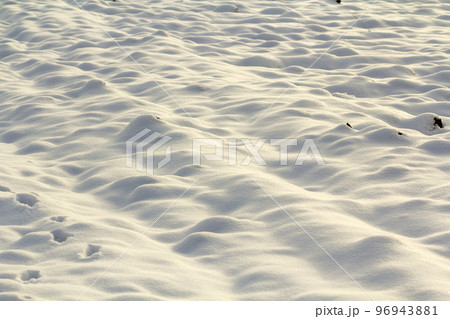 White surface of clear bright uneven deep snow in empty field, rural landscape on sunny winter frosty cold day. Shiny clean seasonal background, wallpaper theme. 96943881