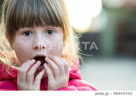 Portrait of a pretty child girl making amazed shoked expression on her face outdoors. Portrait of a pretty child girl making amazed shoked expression on her face outdoors. 96945502