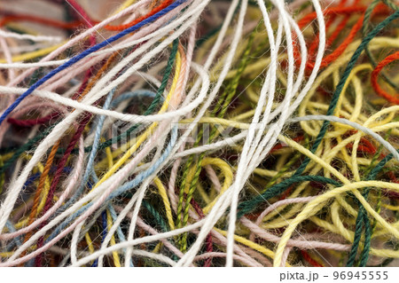 Multi-colored tangled colorful needlecraft silk thread rope. Macro shot. Abstract colors background Multi-colored tangled colorful needlecraft silk thread rope. Macro shot. Abstract colors background 96945555