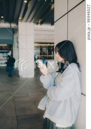 女子高生が街中でスマホを持った写真 96946027