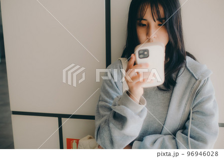女子高生が街中でスマホを持った写真 96946028