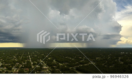 Landscape of dark ominous clouds forming on stormy sky during heavy thunderstorm over rural town area Landscape of dark ominous clouds forming on stormy sky during heavy thunderstorm over rural town area 96946326